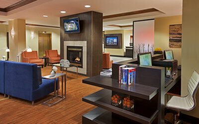 Lobby lounge area with fireplace and business center with computers and printer at Courtyard By Marriott Toronto Airport.