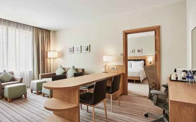 King bedroom suite with living room, sofa bed and working station at the Hilton Garden Inn Dubai Mall of the Emirates.