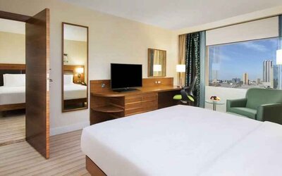 Comfortable queen room with window view and working desk at the Hilton Ras Al Khaimah Beach Resort.
