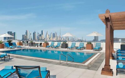 Beautiful outdoor pool with deck and pool chairs at the Hilton Garden Inn Dubai Al Mina