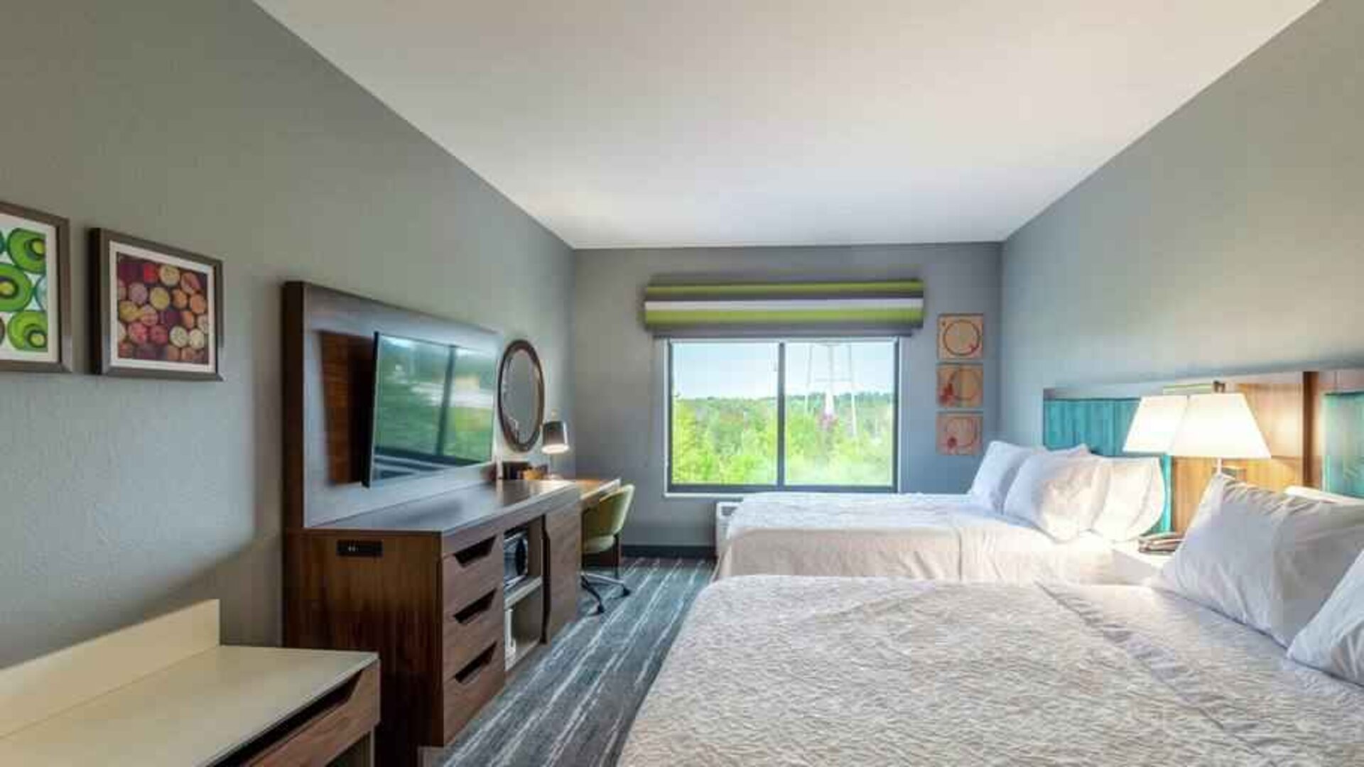 Double queen bedroom with desk, window and TV screen at the at the Hampton Inn Madison, OH.