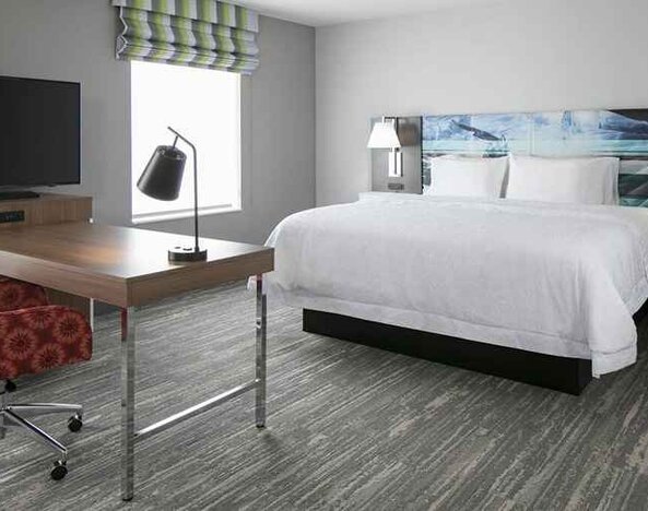 delux king-sized bed with work desk at Hampton Inn Wichita Northwest.