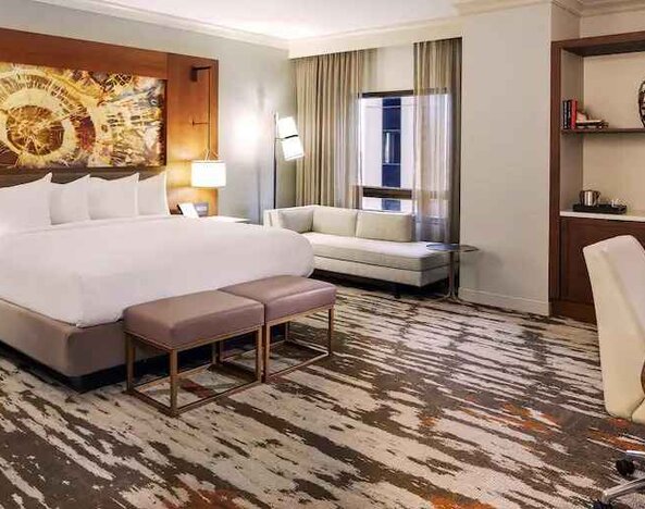 Stunning presidential bedroom with king size bed, sofa and working station at the Hilton Denver City Center.