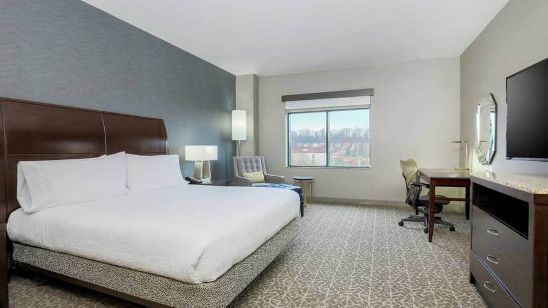 Spacious king size suite with 1 king bed, desk. and chairs at the the Hilton Garden Inn Arlington Shirlington