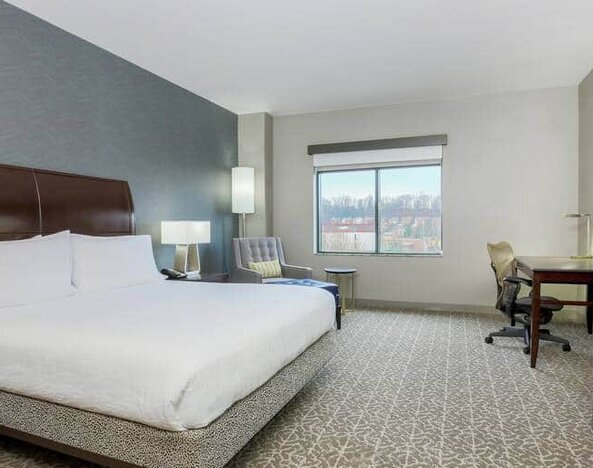 Spacious king size suite with 1 king bed, desk. and chairs at the the Hilton Garden Inn Arlington Shirlington