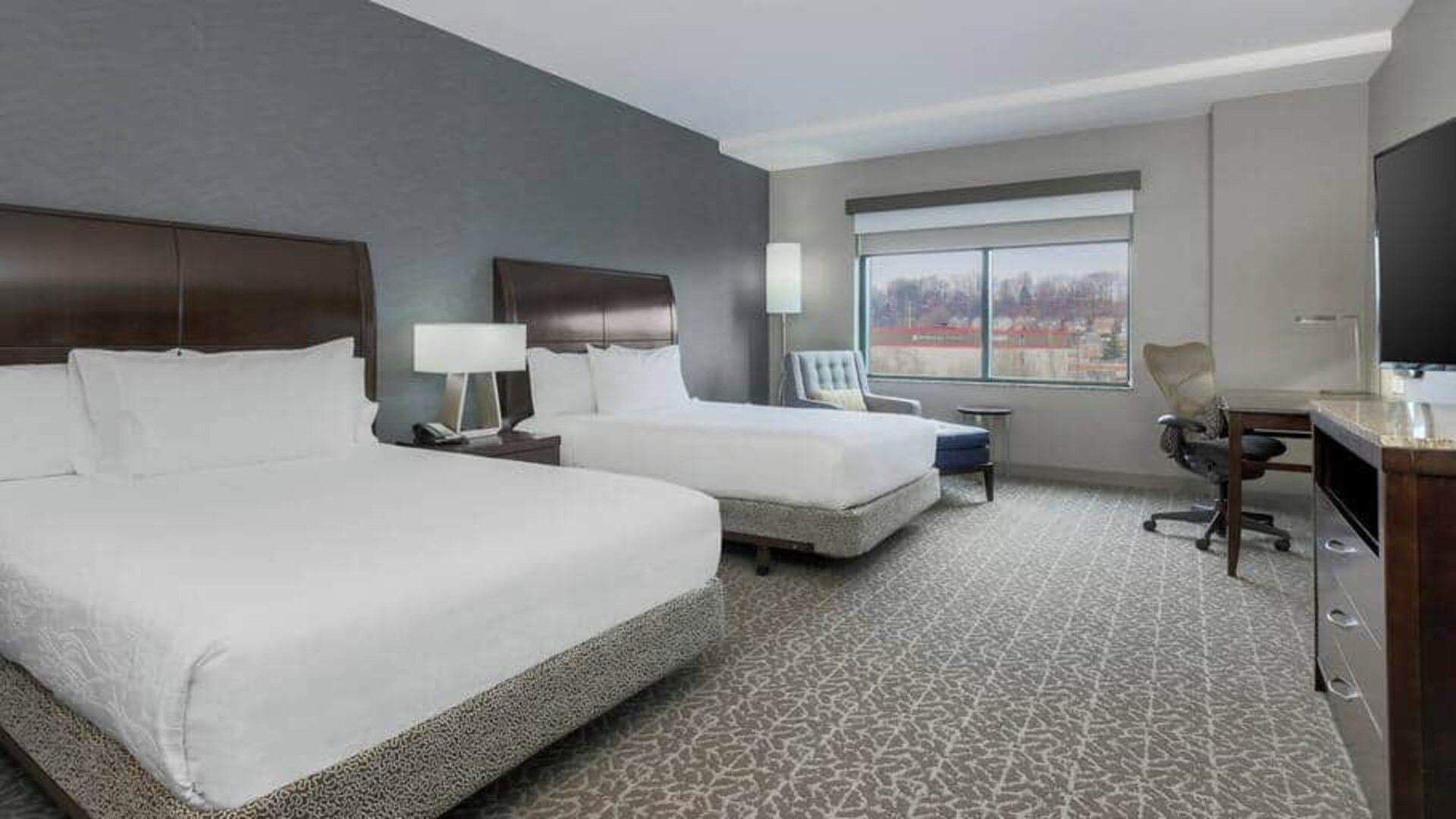 Spacious suite with 2 queen beds, chairs and desk set up at the Hilton Garden Inn Arlington Shirlington