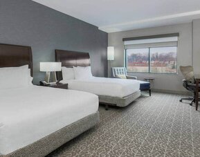 Spacious suite with 2 queen beds, chairs and desk set up at the Hilton Garden Inn Arlington Shirlington