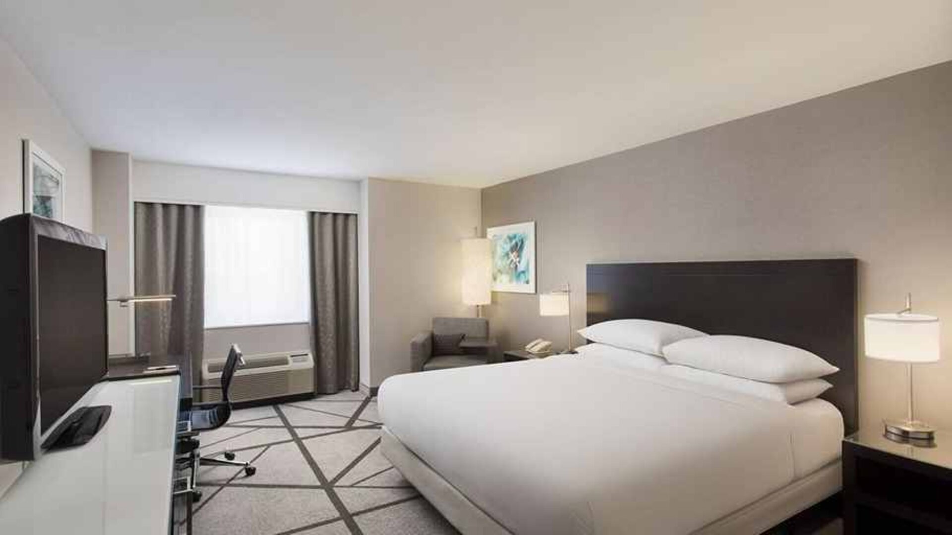 beautiful, luxury king suite with work desk and natural light at DoubleTree by Hilton Los Angeles - Norwalk.