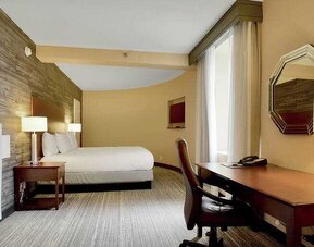 Desk and king size bed in a hotel room at the DoubleTree Suites by Hilton Houston by the Galleria.