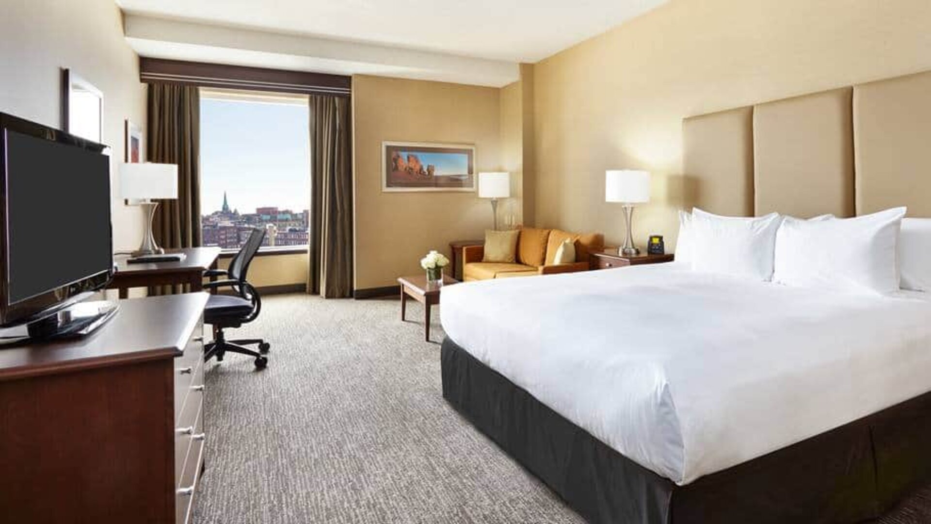King room with 1 king bed, work desk and view of downtown at the Hilton Saint John.