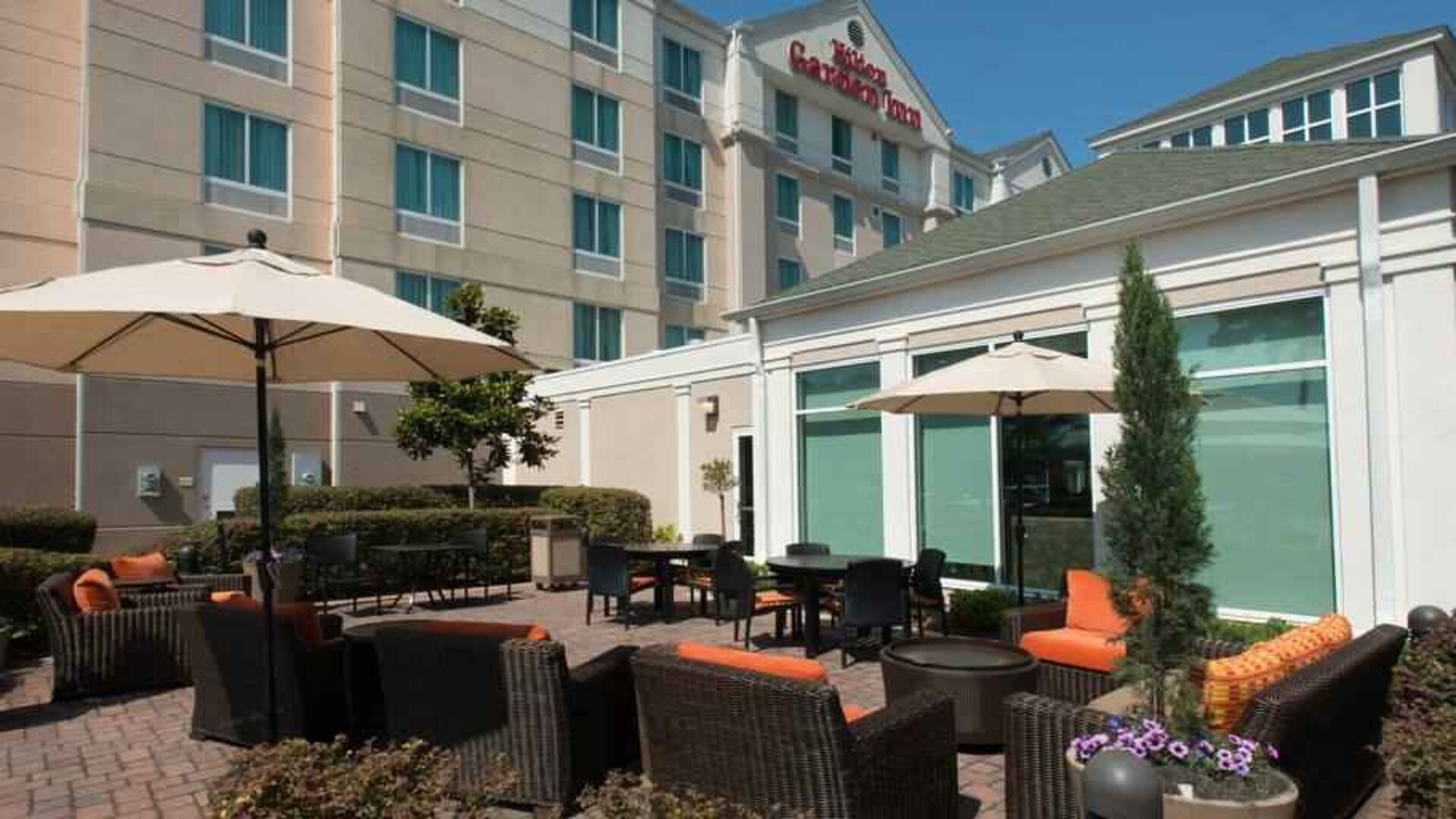 Outdoor patio area with lounges and tables perfect as workspace at the Hilton Garden Inn Tallahassee Central.