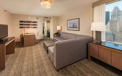 Spacious living room with working station in a king suite at the Embassy Suites by Hilton Chicago Magnificent Mile.