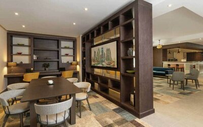 Spacious work lounge area in the lobby with large wooden bookshelves making for cozy partitions.