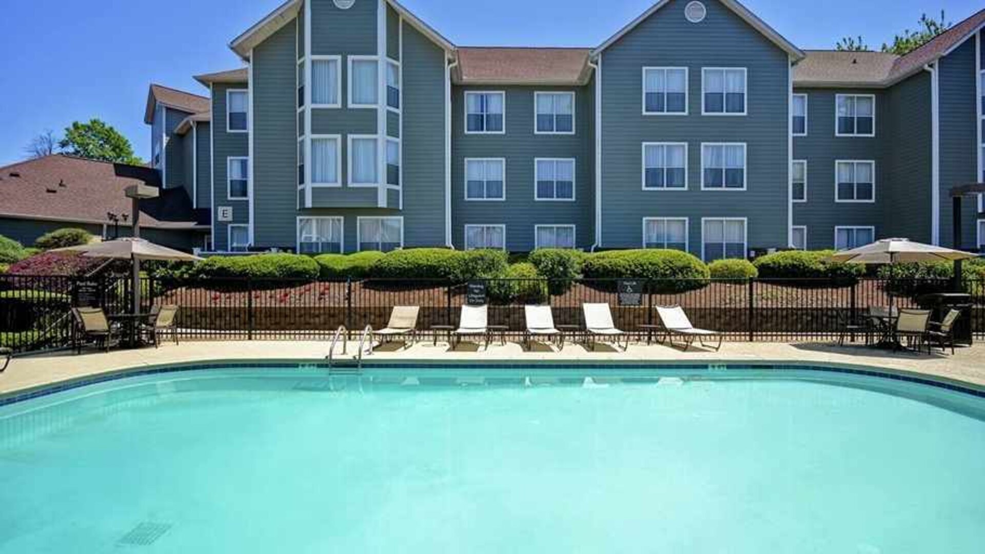 Large outdoor pool with tanning beds and seating at Homewood Suites by Hilton Atlanta-Galleria/Cumberland.
