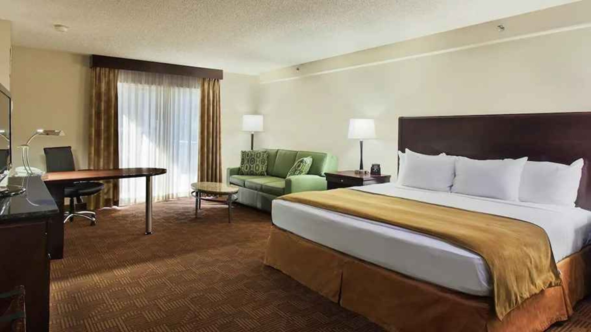 luxurious king suite with work desk and lounge area at DoubleTree by Hilton Hotel Sacramento.