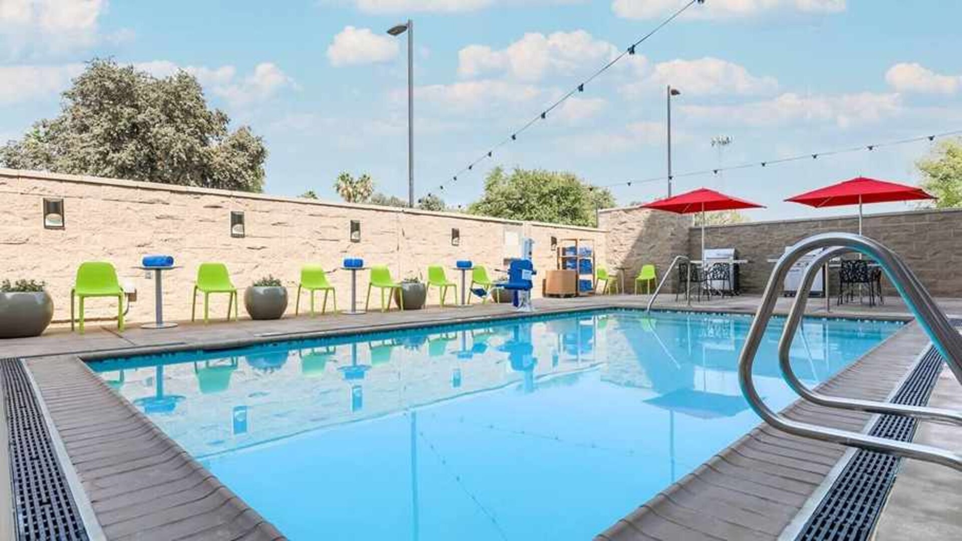 beautiful and large outdoor pool with colorful seating at Home2 Suites by Hilton West Sacramento.