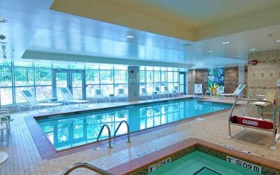 beautiful indoor pool with seating at Hilton Garden Inn Rockville-Gaithersburg.