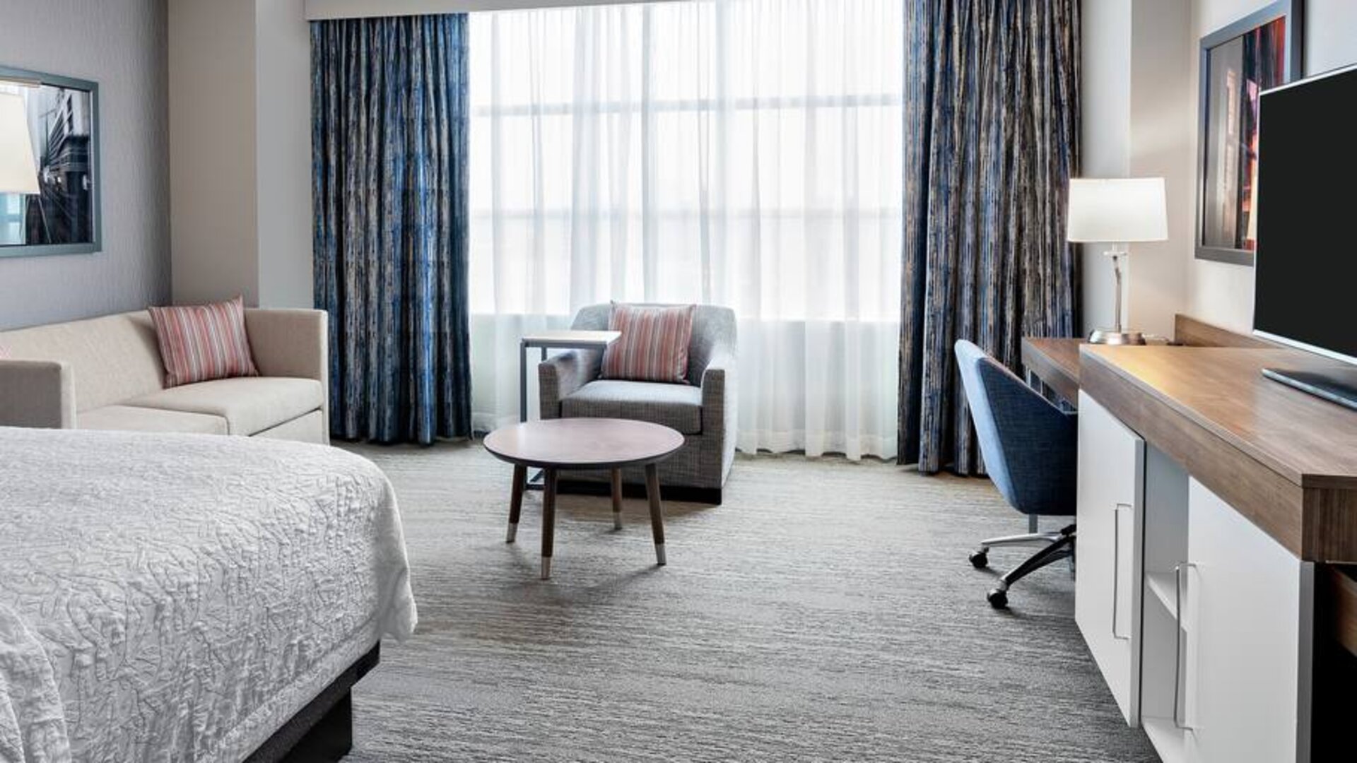 King size bed, sofas and desk in a king room at the Hampton Inn Chicago McCormick Place.