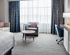 King size bed, sofas and desk in a king room at the Hampton Inn Chicago McCormick Place.