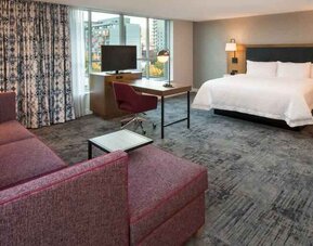 King bedroom with sofa and desk at the Hampton Inn & Suites by Hilton Portland-Pearl District.