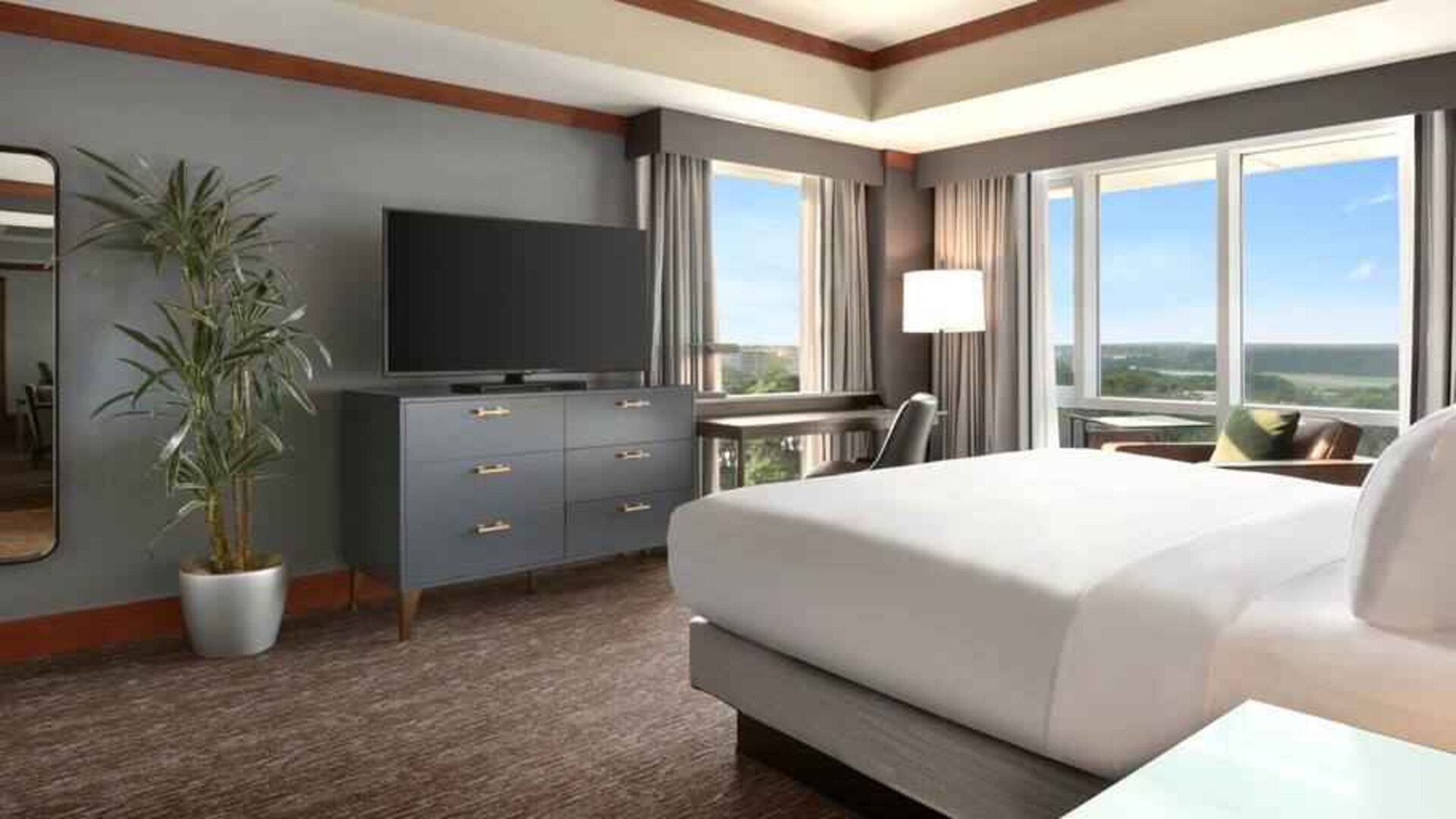 President suite with king size bed, desk and view at the Hilton Baltimore BWI Airport.