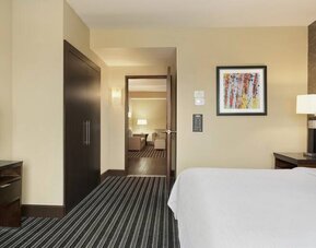 King size bed and TV screen in a king bedroom at the Embassy Suites by Hilton Salt Lake City West Valley.