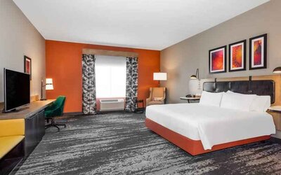 Spacious and comfortable king bedroom with window and TV screen at the Hilton Garden Inn Hays.