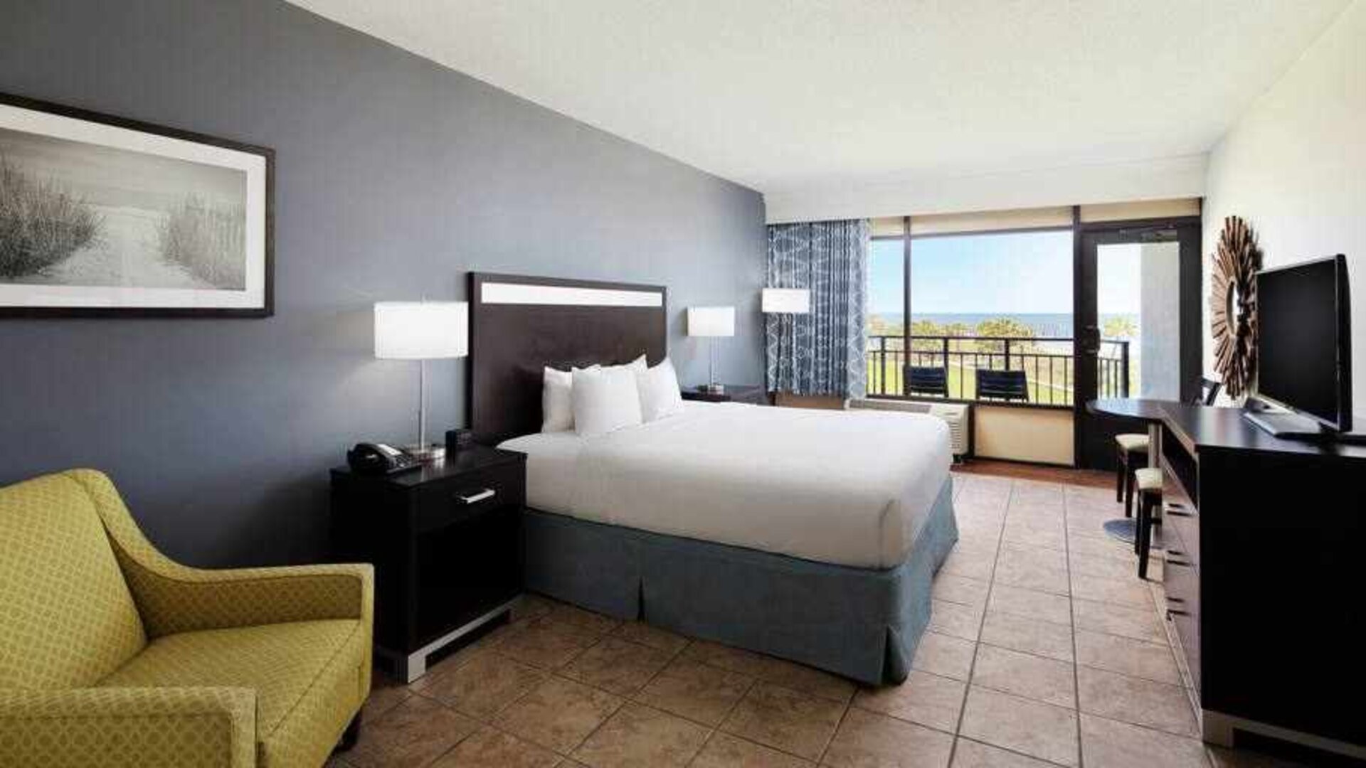 King bedroom with balcony and ocean view at the DoubleTree by Hilton Myrtle Beach.