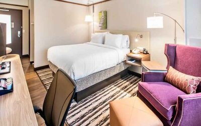 Desk, sofa and king size bed in a king bedroom at the Hilton Garden Inn Minneapolis Airport Mall of America.