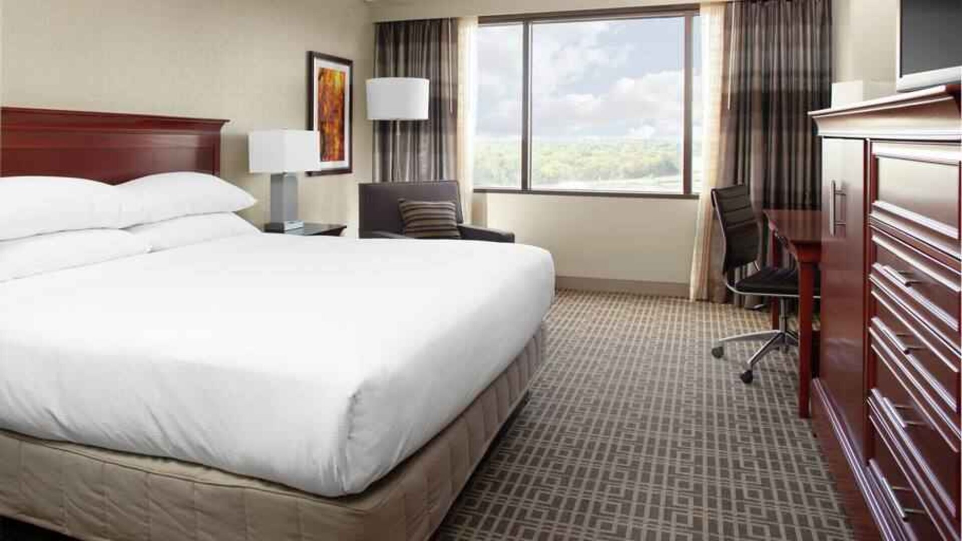 King size bed and desk in a king guestroom at the DoubleTree by Hilton Kansas City - Overland Park.