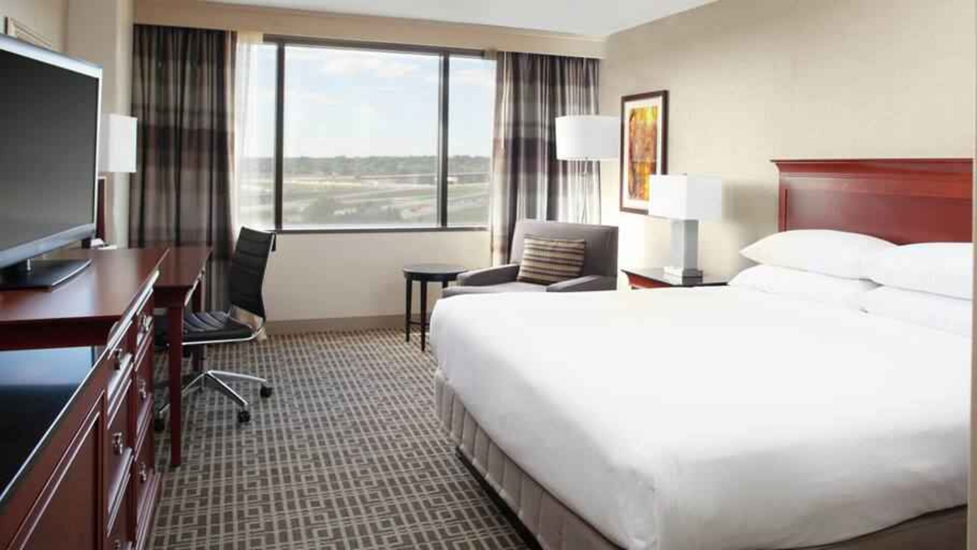 Bright and comfortable king bedroom with window at the DoubleTree by Hilton Kansas City - Overland Park.