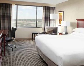 Bright and comfortable king bedroom with window at the DoubleTree by Hilton Kansas City - Overland Park.