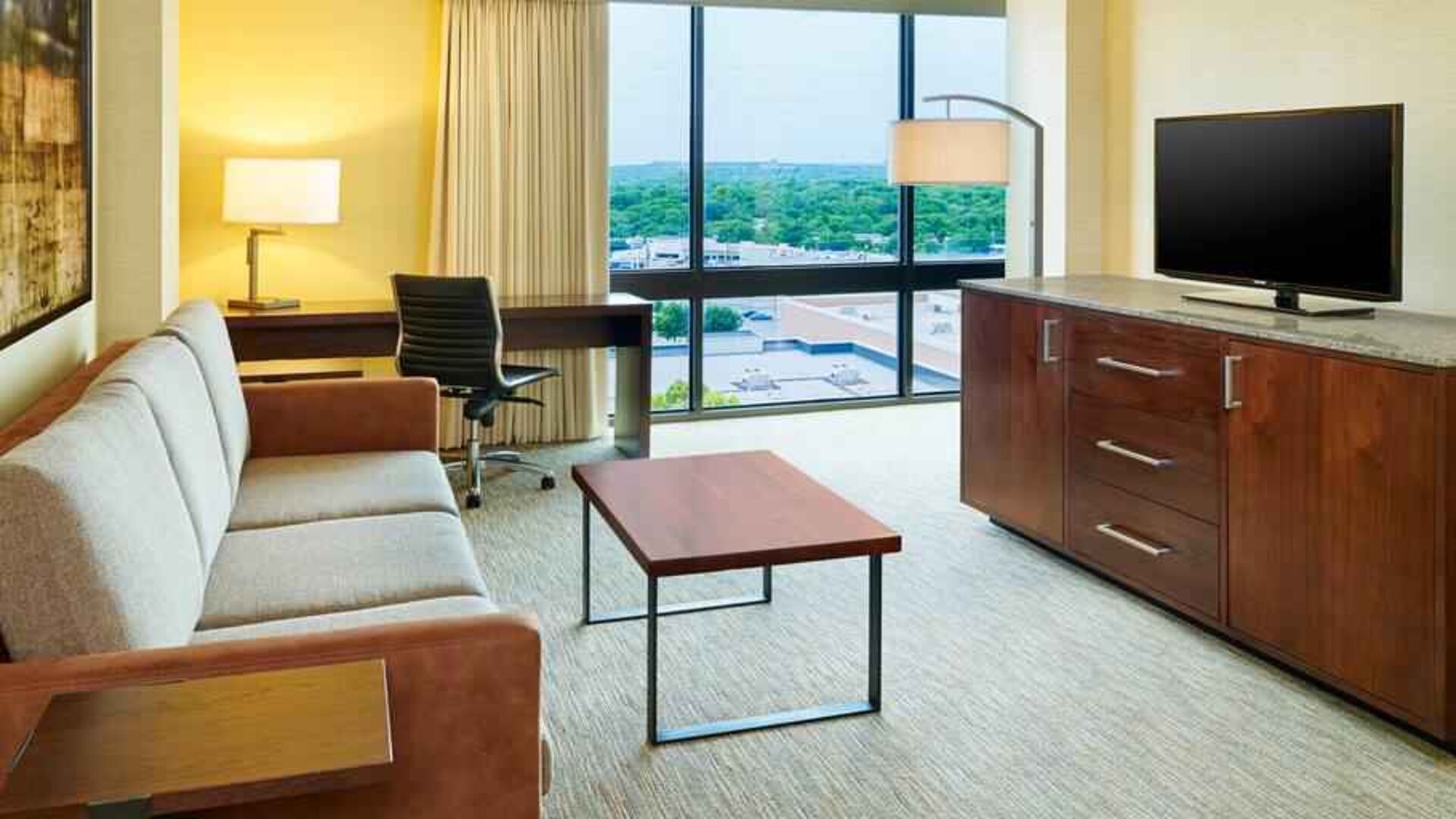 Living area with sofa and desk in a king suite at the Hilton San Antonio-Airport.
