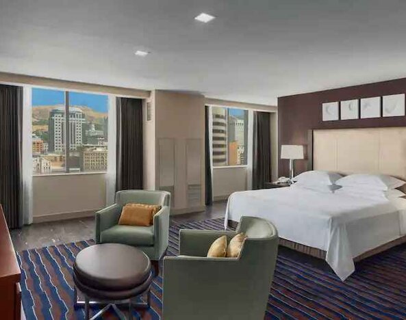 Spacious bedroom with king size bed in a hotel suite at the Hilton Salt Lake City Center.