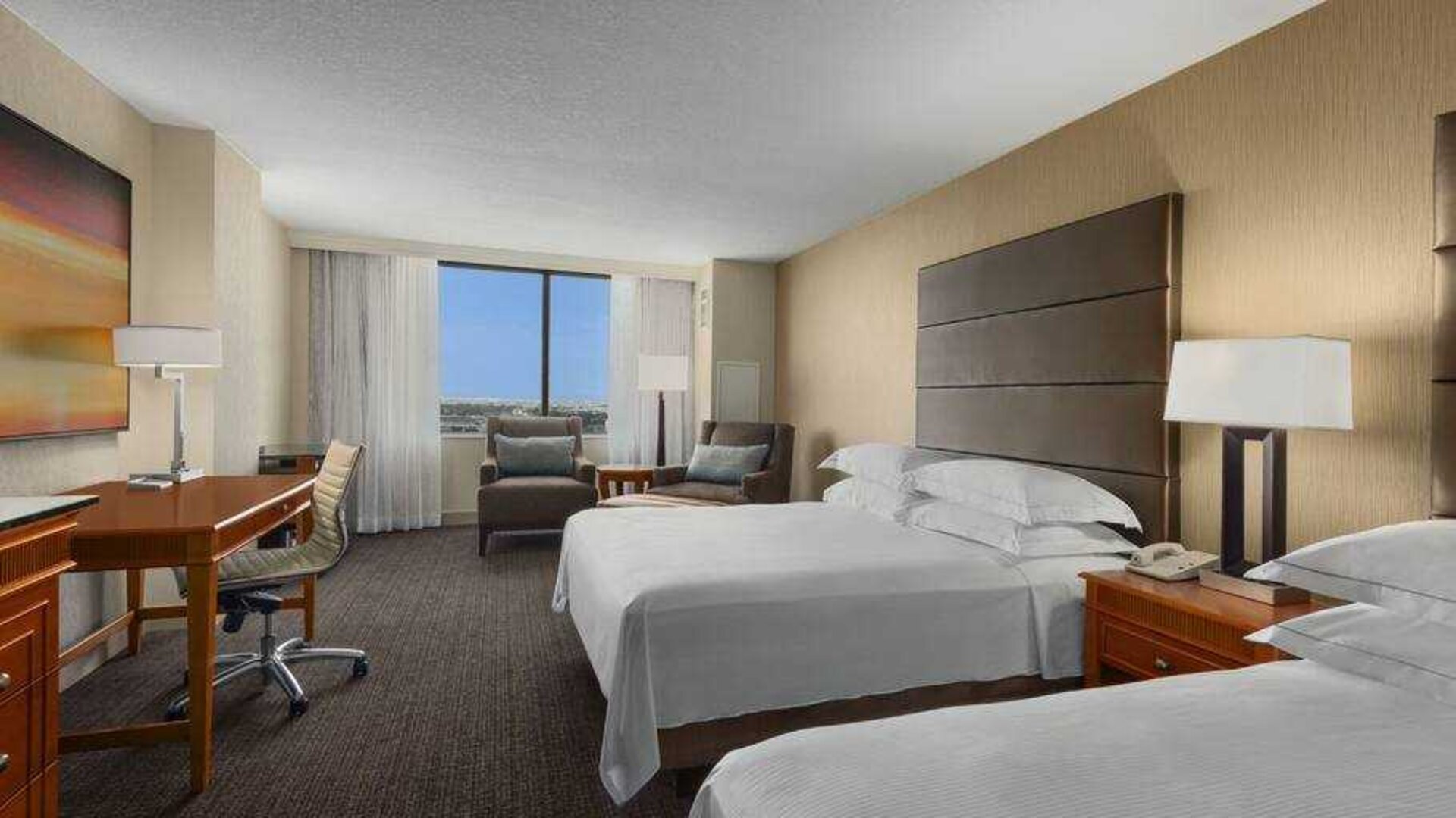 Bright double queen room with window and desk at the Hilton Salt Lake City Center.