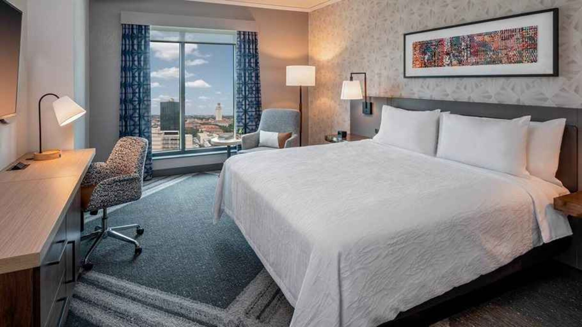 Comfortable king bedroom with city views and natural light at Hilton Garden Inn Austin University.