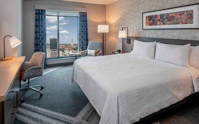 Comfortable king bedroom with city views and natural light at Hilton Garden Inn Austin University.