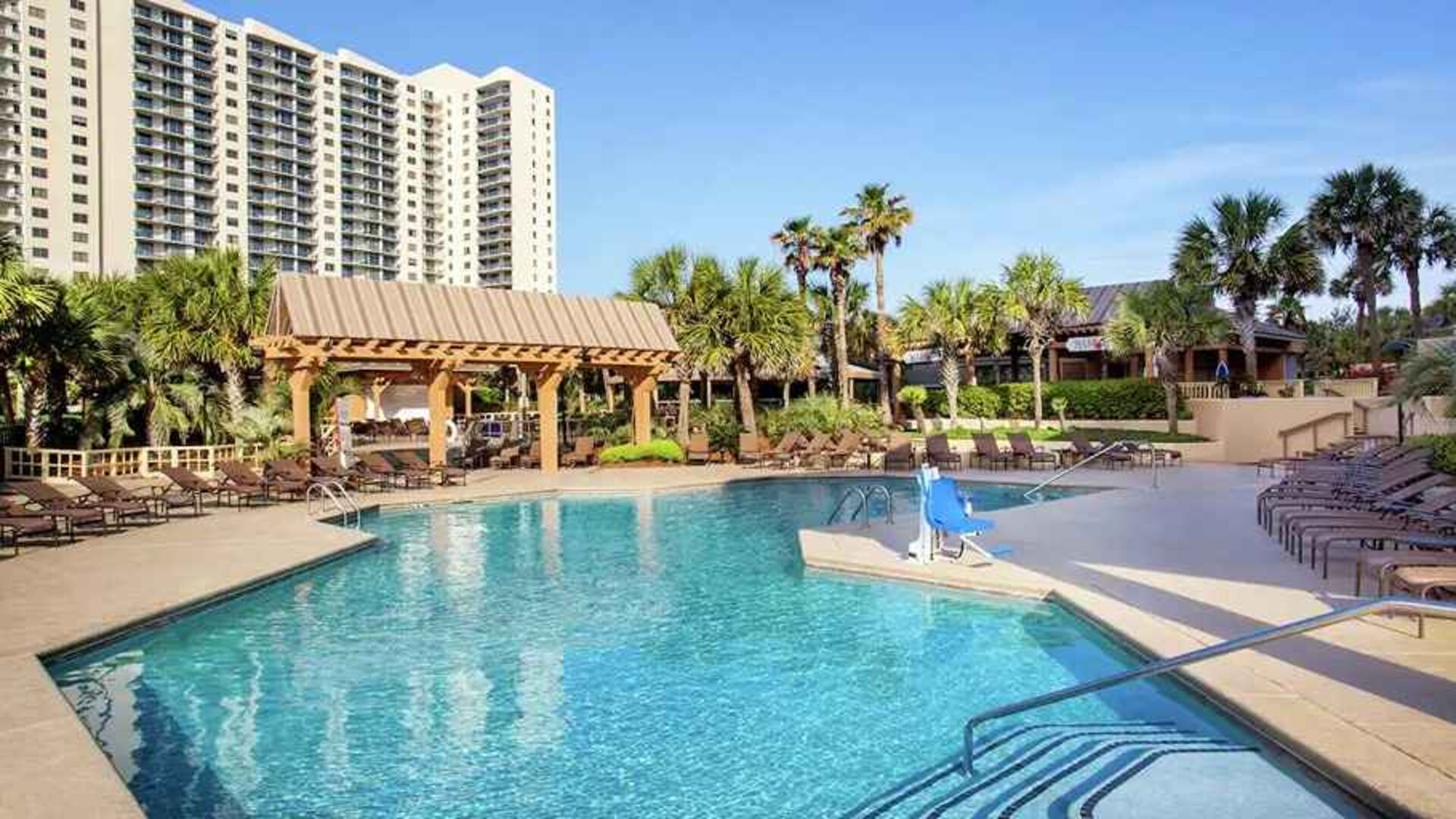 stunning outdoor pool with sun beds and outdoor seating at Kingston Plantation Condos.