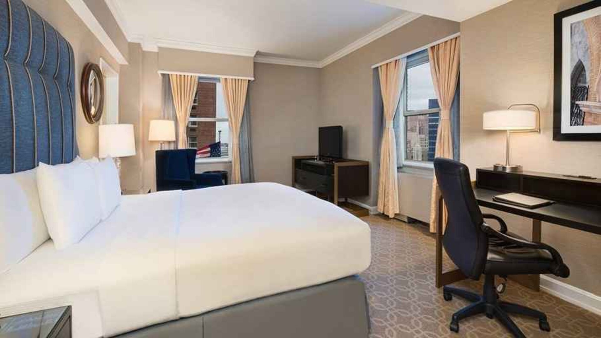 Delux king room with TV, work desk, and natural light at Hilton Milwaukee City Center.