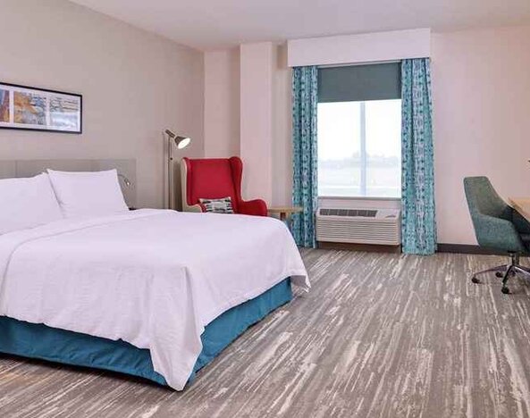 spacious king room with work desk, TV, and natural light aat Hilton Garden Inn Kansas City Airport.