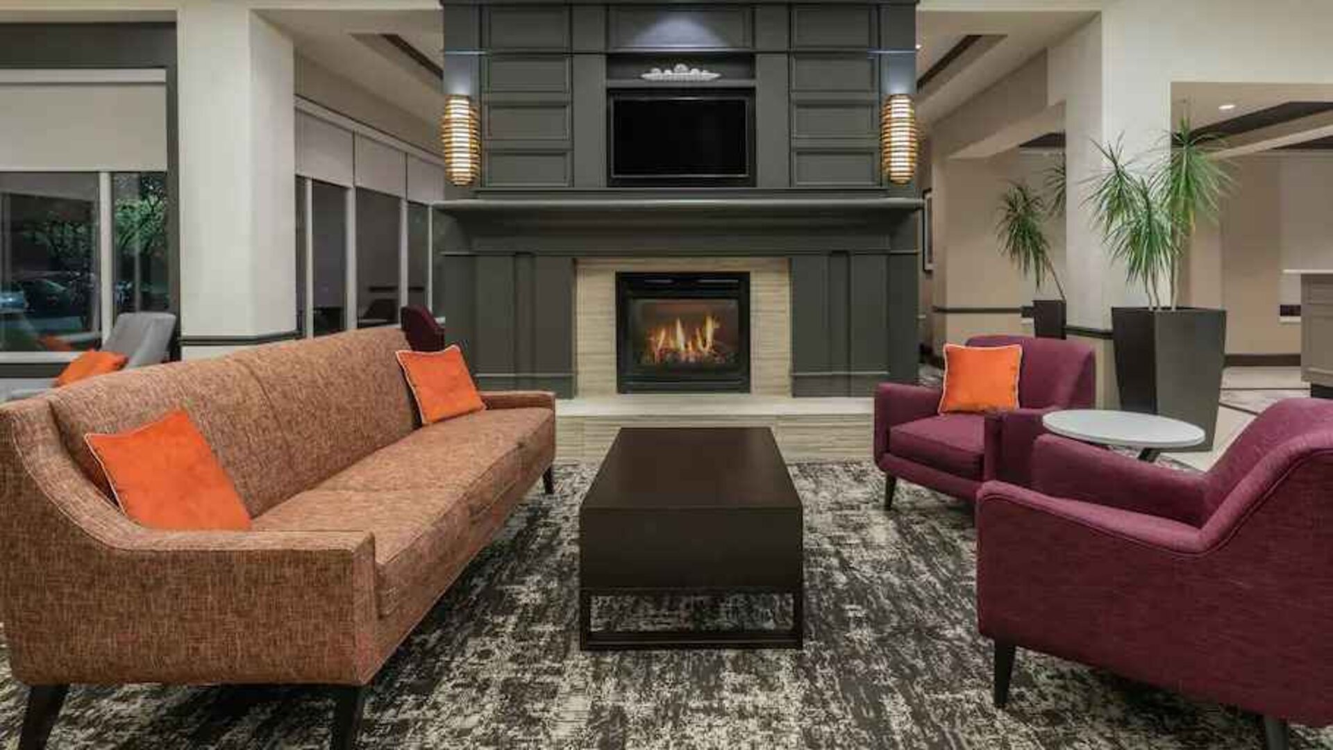 Comfortable workspace by the fireplace in a hotel lobby at the Hilton Garden Inn Blacksburg University.