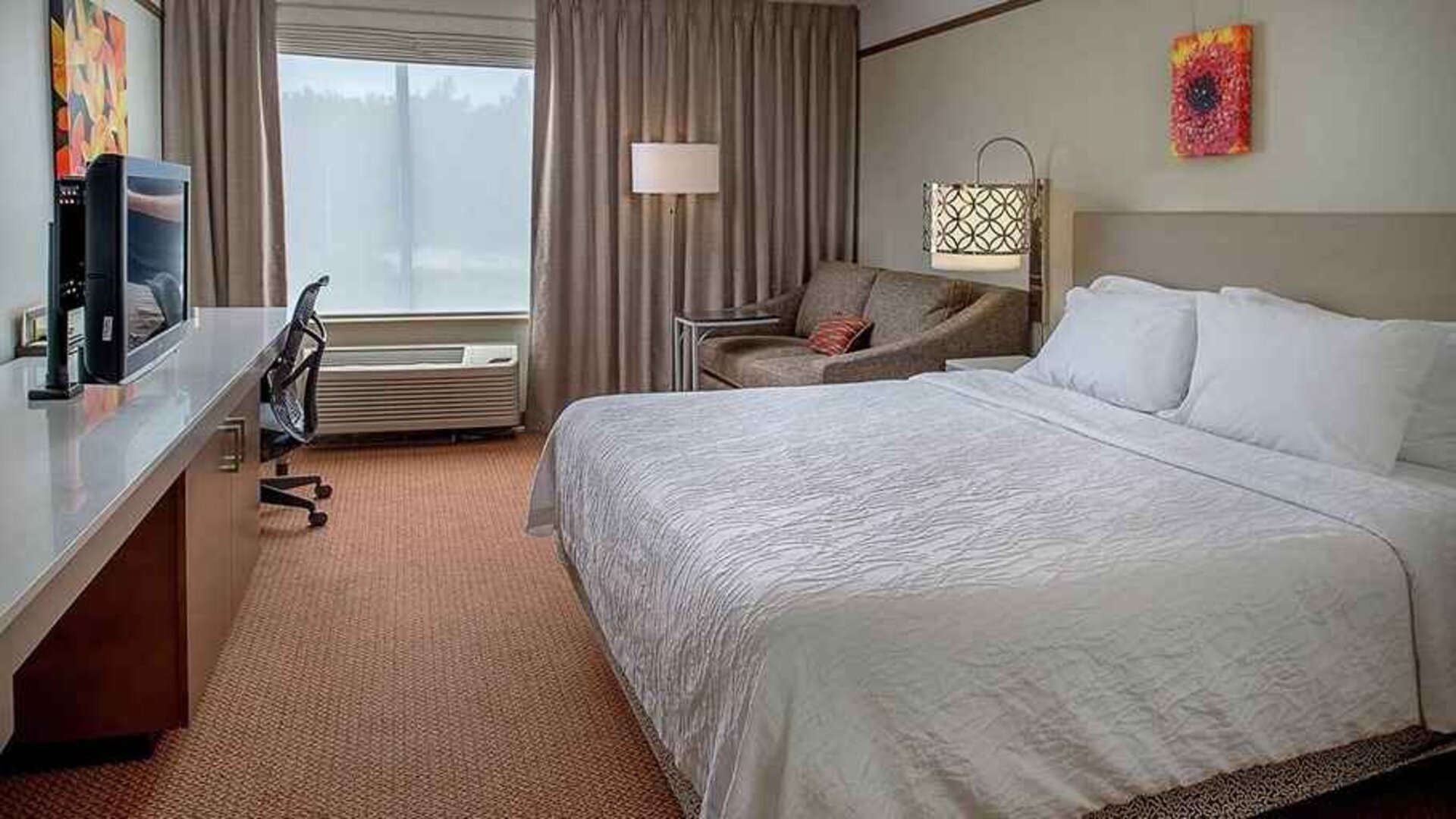 comfortable king delux room with TV and work desk ideal for working remotely at Hilton Garden Inn St. Louis/Chesterfield.