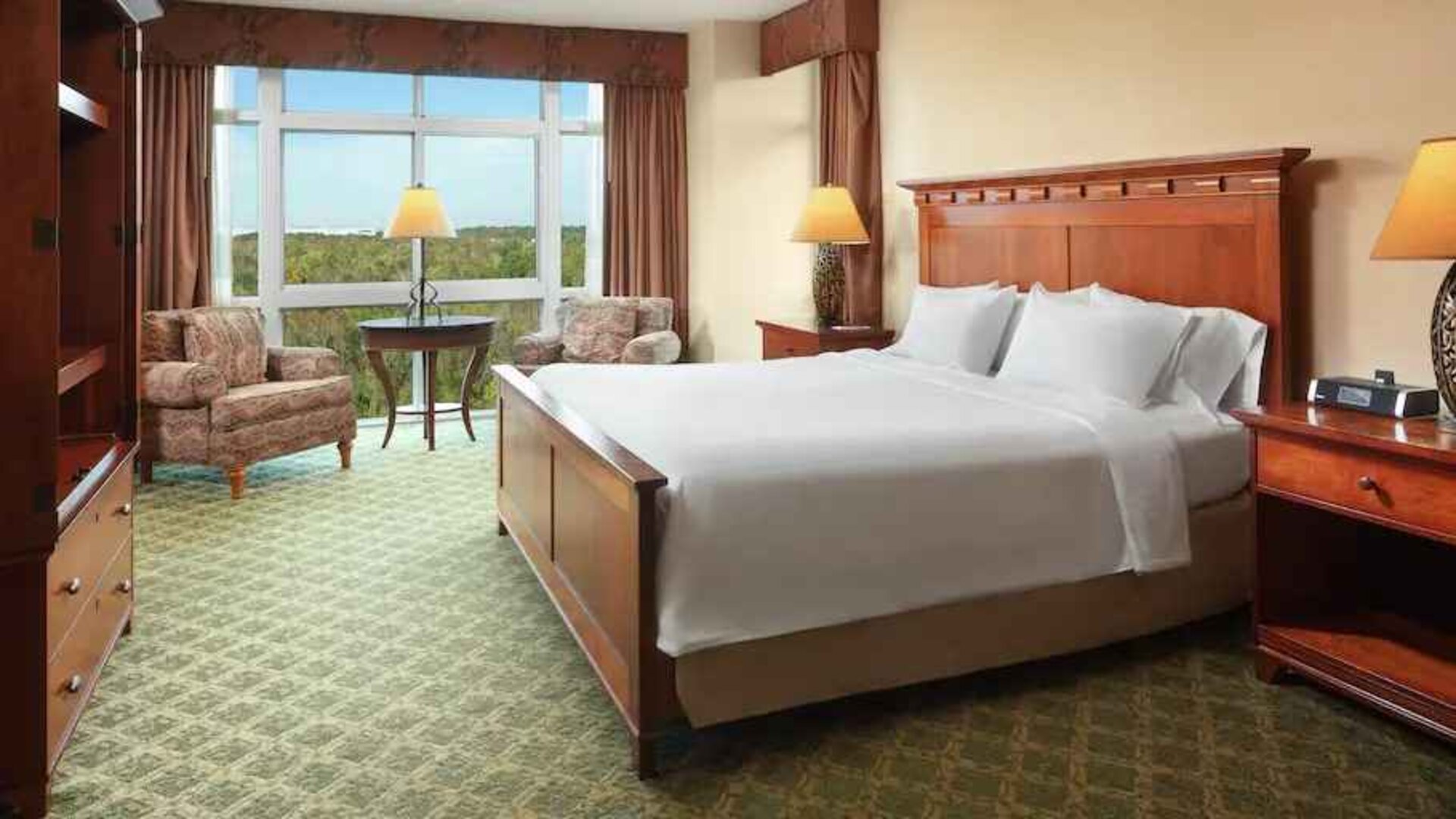 Bright king suite with window and sofas at the Embassy Suites by Hilton Charleston Airport Convention Center.