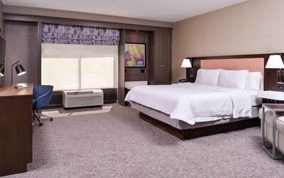 Spacious and bright king guestroom with window and desk at the Hampton Inn Albuquerque, University-Midtown (UNM).