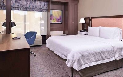 Comfortable king size bed in a hotel room at the Hampton Inn Albuquerque, University-Midtown (UNM).