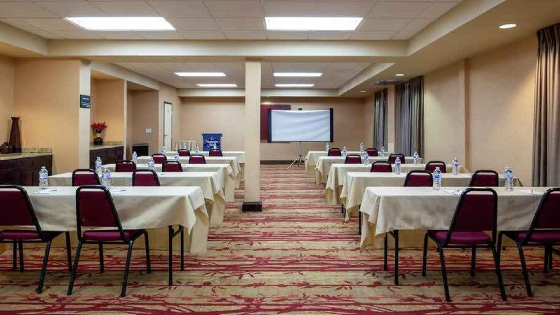 Large meeting room with tables and chairs at the Hampton Inn Albuquerque, University-Midtown (UNM).