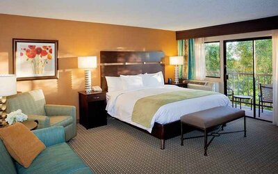 spacious king suite with balcony seating and lounge area at DoubleTree by Hilton Hotel Santa Fe.