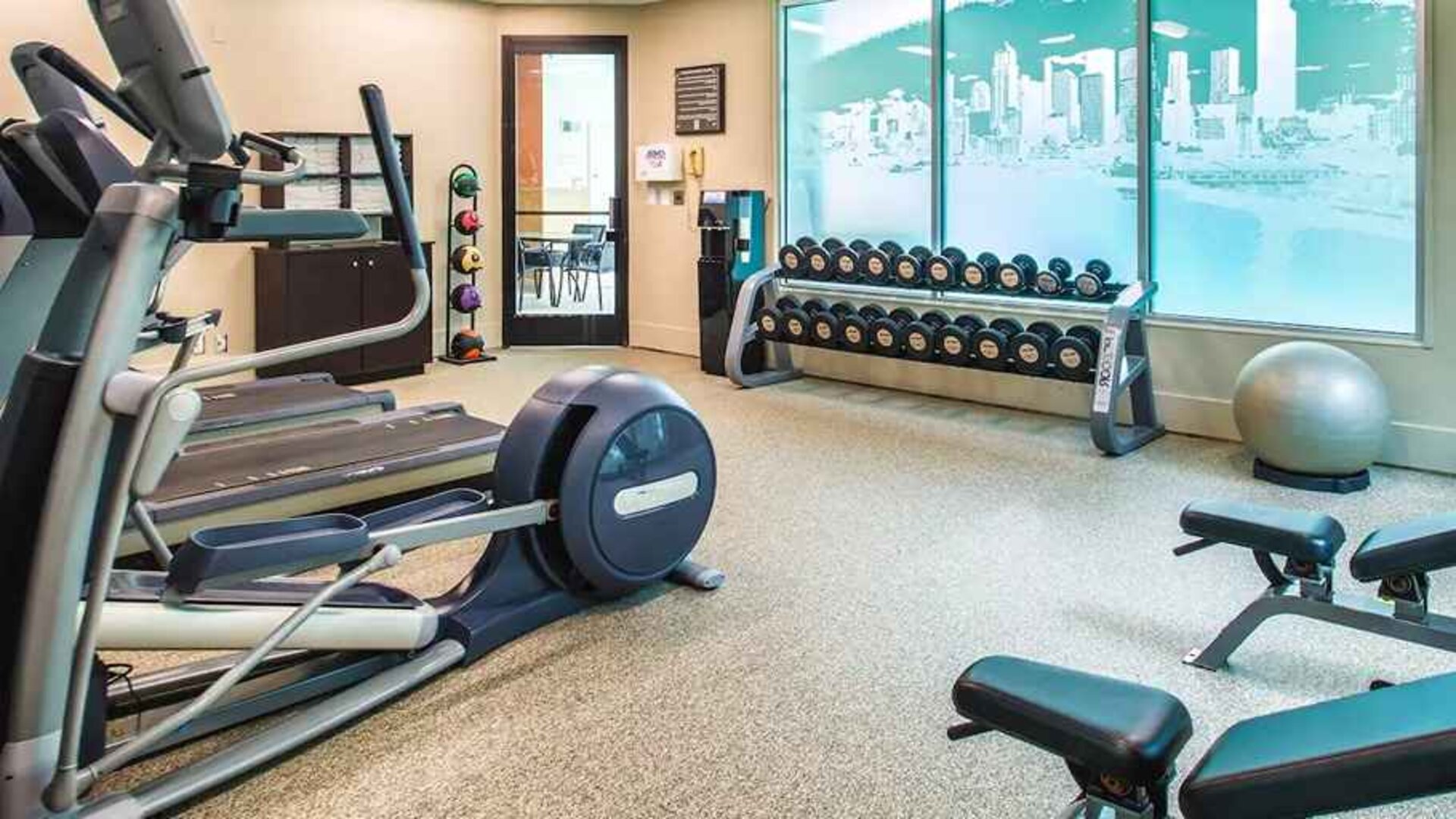 Fully equipped fitness center with treadmills and weights at at Embassy Suites by Hilton Seattle Tacoma International Airport.