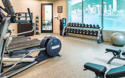 Fully equipped fitness center with treadmills and weights at at Embassy Suites by Hilton Seattle Tacoma International Airport.