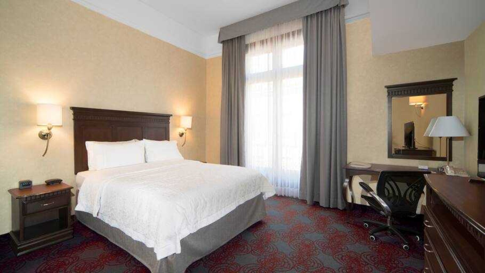 Bright king bedroom with desk and window at the Hampton Inn & Suites Mexico City - Centro Historico.